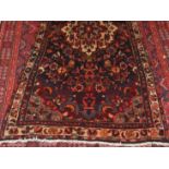 A Persian woollen rug, the medallion floral field within trailing tramline floral borders,