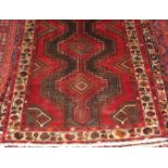 A Kurdish woollen rug, the wide poled field within trailing tramline floral borders,