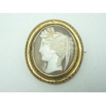 A Victorian yellow metal and shell cameo brooch bearing a carved relief profile of Demeter, being