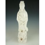 A large Blanc de Chine porcelain figure of Guanyin, depicted holding a gourd in her left hand and