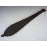 An antique Australian aboriginal woomera, bearing carved linear geometric decoration, 64 cm