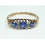 A 9ct gold, sapphire and diamond dress ring, in a lenticular claw-set arrangement of three graded