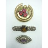 Three Victorian and later brooches, comprising one rolled gold and paste boss brooch, a silver and