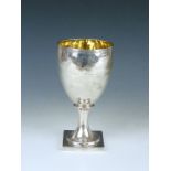 A George III silver presentation cup, having an ovoid bowl over a flared stem and square foot,
