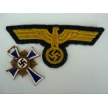 A Kriegsmarine national emblem and a German Third Reich Mother's Cross in bronze