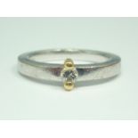 A contemporary 18ct white gold diamond solitaire, the brilliant of approximately .13ct set between a