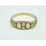 An early 20th Century 18ct gold, opal and diamond dress ring, having a raised navette face with