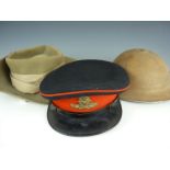 A Second World War British army slouch hat, a South African steel helmet and an artillery forage