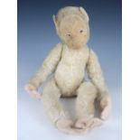 An inter-War plush toy monkey, having pressed felt face with glass eyes, articulated head and