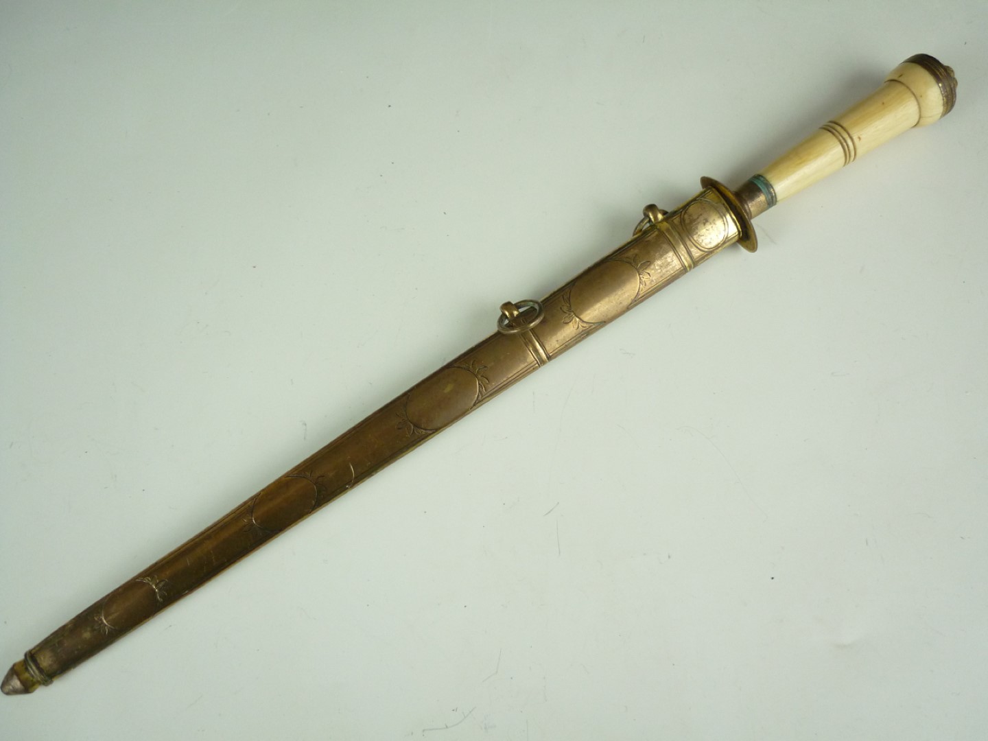 A Georgian ivory handled dirk, having a blue-and-gilt blade, single-fullered and decorated in a