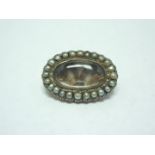 A late Georgian oval yellow metal and hairwork mourning brooch, with pearl-set bezel, 22 mm x 15 mm