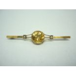 An early 20th Century 9ct gold, citrine and pearl bar brooch, having a circular collet set stone