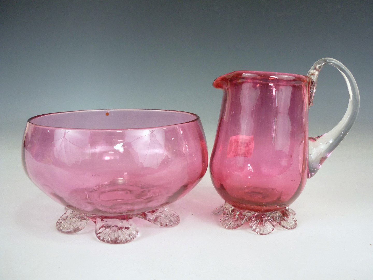 Two pieces of Victorian cranberry glass, comprising sugar bowl and cream jug, each having