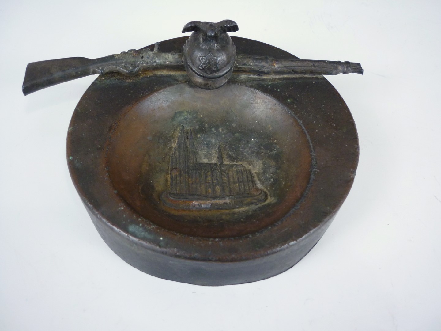 An early 20th Century German bronzed spelter dish modelled as a Garde du Corps helmet and rifle,