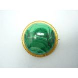 A large Victorian yellow metal and malachite brooch, the circular cabochon collet set in a