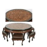 Mesa oval oriental con seis banquetas, s.XX. Madera profusamente tallada con escenas de guerreros en