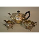 Silver three piece tea service of oval baluster fluted design with scroll feet and handles,