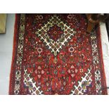 20th Century Hamadan rug with medallion and all-over Herati design on a red ground with borders,