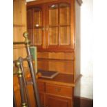 Reproduction cherry wood display cabinet with a pair of glazed doors above two drawers and two