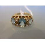 Three stone aquamarine and four stone diamond set ring in a carved half hoop setting