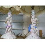 Pair of Continental porcelain table lamps in the form of cherubs supporting cornucopia