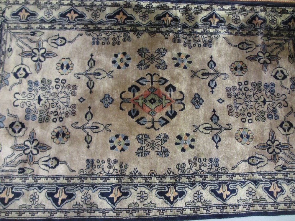 Indo Persian rug with stylised floral design on a fawn ground with borders, 176cms x 97cms