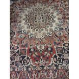 Baktiari rug with medallion and all-over stylised floral design on a red ground with borders,