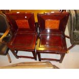 Pair of Chinese carved hardwood side chairs with panel backs and seats on square cut and shaped