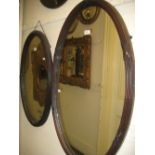 Early 20th Century oval mahogany framed wall mirror together with a similar smaller wall mirror