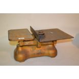 Set of gold painted iron W. and T. Avery balance scales with three small weights, marked G.P.O,