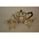 Silver three piece tea service of circular shaped design with lions paw feet and scroll handles,