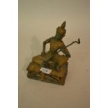 Modern green and gilt patinated bronze figure of a seated deity playing a musical instrument