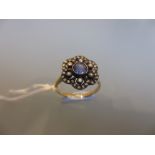 Antique style white and yellow metal set sapphire and diamond flower head ring of pierced design