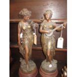 Pair of late 19th / early 20th Century spelter figures of maidens holding a mandolin and flowers on