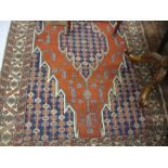 Early 20th Century Kurdish rug with a single medallion on a brick red ground with blue ground