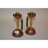 Pair of Arts and Crafts copper and brass chamber candlesticks, after a design by Christopher
