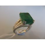 18ct White gold emerald cut emerald ring, approximately 7.06ct with diamond set shoulders