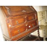 Early 20th Century oak bureau, the fall front above two drawers and barley twist supports