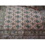 Modern Indo Persian rug of Turkoman design with four rows of gols on a pink ground with borders,