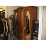 Early 20th Century blond oak semi bow fronted wardrobe, the moulded cornice above two small