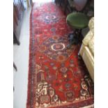 Kurdish runner with twin medallion designs on red ground,