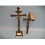 Continental ebony and silver plated crucifix together with a similar brass crucifix