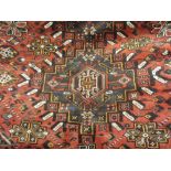 Hamadan rug of twin medallion design with multiple borders on a red ground,