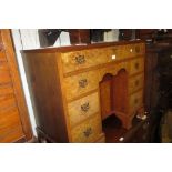 Mid 20th Century burr walnut kneehole desk with a plain top above a central cupboard surrounded by