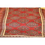 Indo Persian rug of Turkoman design with all-over hooked gols on a wine ground with borders