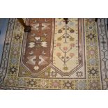 Kazak rug having stylised floral panelled design on cream and brown ground with multiple borders, 3.