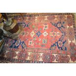 Anatolian rug with stylised flower head designs on a red ground with corner designs and borders