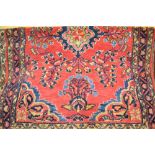 Hamadan rug of centre medallion and all-over floral design with multiple borders on a red ground,