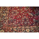 Persian design carpet with all-over floral pattern on a red ground with borders (two cuts to one