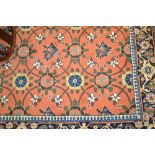 Indo Persian carpet with all-over stylised floral design on a salmon pink ground with borders,